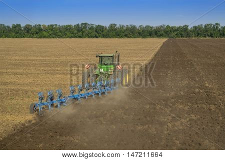 KRASNODAR REGION, RUSSIA - AUG 19, 2015: Tractor in dust plow big field, In 2015 in Krasnodar region yields reached record level - 58.4 centners per hectare