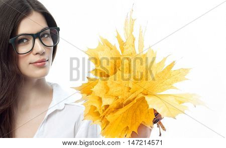 closeup portrait of attractive  caucasian smiling woman brunette isolated on white studio shot lips toothy smile face hairlooking at camera tooth hand holding yellow marple autumn leaves