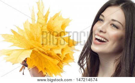 closeup portrait of attractive  caucasian smiling woman brunette isolated on white studio shot lips toothy smile face hair head and shoulders tooth hand holding yellow marple autumn leaves