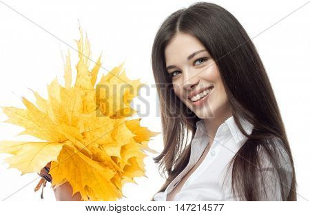 closeup portrait of attractive  caucasian smiling woman brunette isolated on white studio shot lips toothy smile face hairlooking at camera tooth hand holding yellow marple autumn leaves