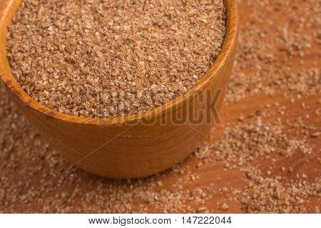 Ground Wheat into a bowl over a wooden table. Trigo para quibe. Kibbeh
