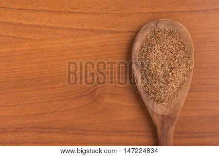 Ground Wheat into a spoon over a wooden table. Trigo para quibe. Kibbeh