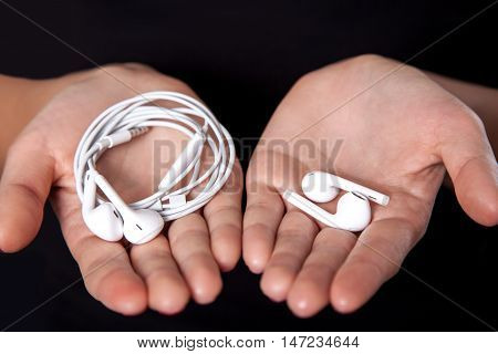 Wireless earphones on human hands. studio shot.