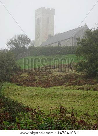 Church in rural landscape photographed at Manorbier in Pembrokeshire