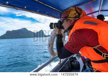 Semporna,Sabah-Sep 10,2016:Unidentified professional photographer using a professional DSLR camera at Semporna,Sabah.Semporna is surrounded by white sand & the turquoise waters of the Celebes Sea.