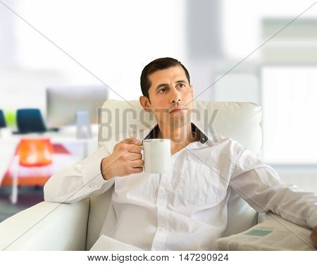 man sitting drinking tea and thinking at the lounge of the office