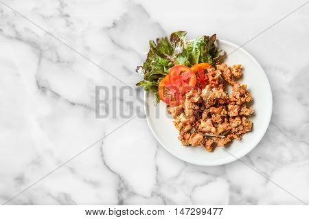 Fried pork in dish on white marble table nackground.