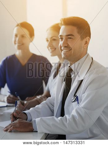hospital, profession, medical education, people and medicine concept - group of happy doctors meeting on presentation at hospital
