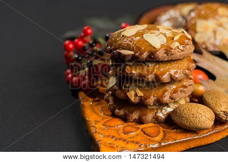 Typical Dutch filled spicy cookies with almonds on autumn colored and dark background
