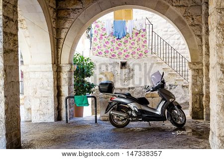 Scooter left in front of the house in an old neighborhood in central Bari