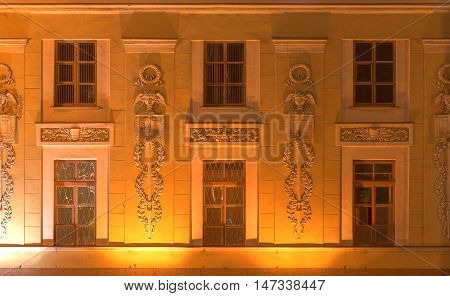 Several windows in a row on night illuminated facade of urban office building front view St. Petersburg Russia