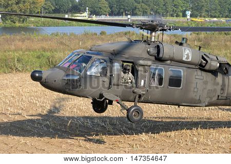 GRAVE NETHERLANDS - SEP 17 2014: American Army Blackhawk helicopter landing in a field.