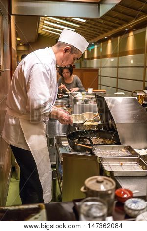 Kyoto, Japan - February 23 2014 - A japanese chef cooking tempura in front of the customers in a restaurant in Kyoto Japan