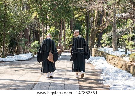 Kamakura, Japan - February 21 2014 - Two monks walking inside the Engaku Ji sacred complex Kamakura Japan
