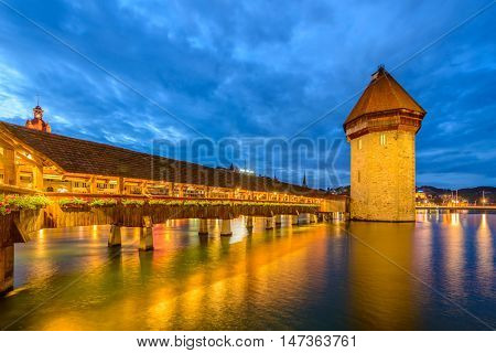 Night view towards Chapel Bridge (Kapellbruecke) together with the octagonal tall tower (Wasserturm) it is one of the Lucerne's most famous tourists attraction
