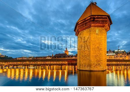 Night view towards Chapel Bridge (Kapellbruecke) together with the octagonal tall tower (Wasserturm) it is one of the Lucerne's most famous tourists attraction