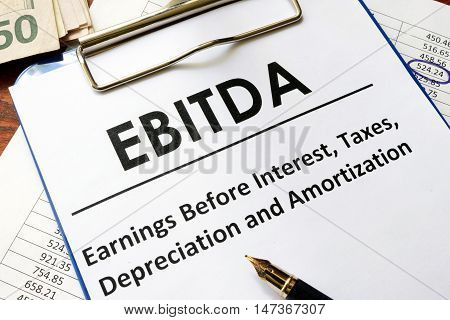 Paper with word ebitda  on a wooden surface.