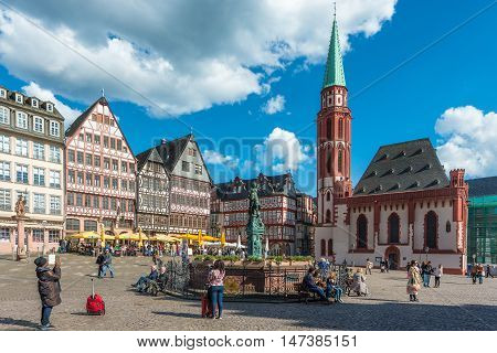 Frankfurt Germany - April 28 2016: Tourist at old traditional buildings in Frankfurt Germany in a summer day. Romerberg town square in Frankfurt Germany
