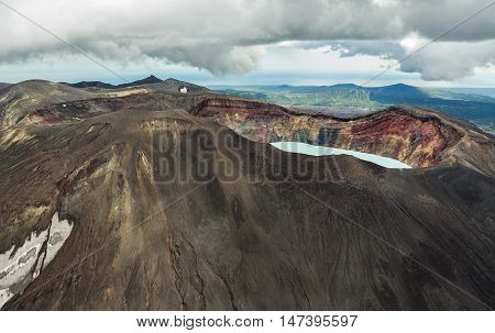 Maly Semyachik is a stratovolcano with acidic crater lake. Kronotsky Nature Reserve on Kamchatka Peninsula. View from helicopter.