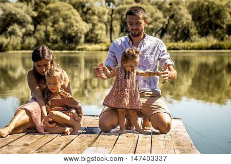Young Family On Pier Near Lake