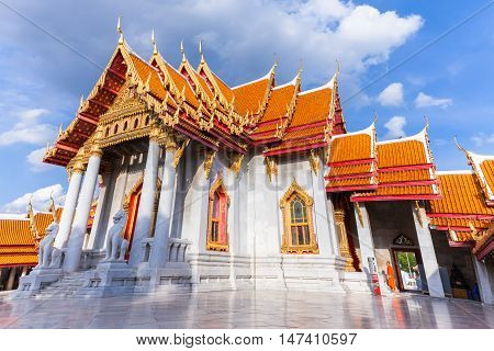 BANGKOK THAILAND - SEPTEMBER 10: Buddhist monk stands on the stairs of Wat Benchamabophit also known as Marble Temple at sunset on Septemper 10 2016 in Bangkok Thailand.