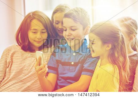 education, elementary school, drinks, children and people concept - group of school kids taking selfie with smartphone in corridor