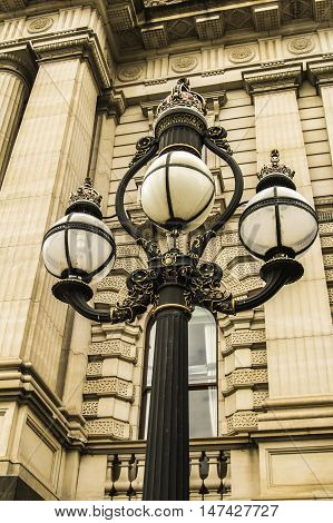 Historical sandstone building with Roman columns and antique street lamps