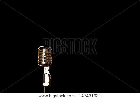 Old retro microphone on a black background