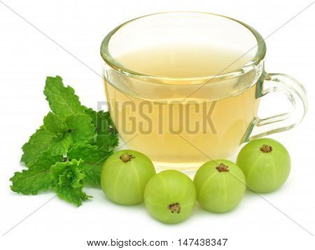 Herbal tea in a cup with amla and mint leaves