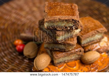 Fresh Dutch filled spicy cookies with almonds on autumn colored and dark background