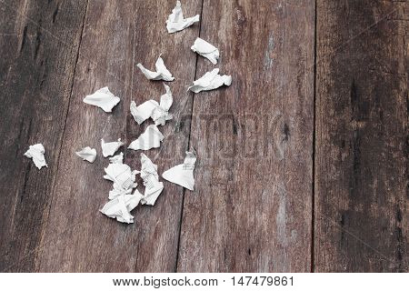 White paper sheet  note rip Pieces and crumpled on a wooden floor with copy space for add text above and may be used as background :