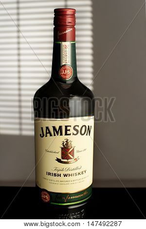 MINSK, BELARUS-AUGUST 25, 2016. Jameson is a blended Irish whiskey produced by the Irish Distillers subsidiary of Pernod Ricard. A bottle Jameson in the room illuminated by the light from the window