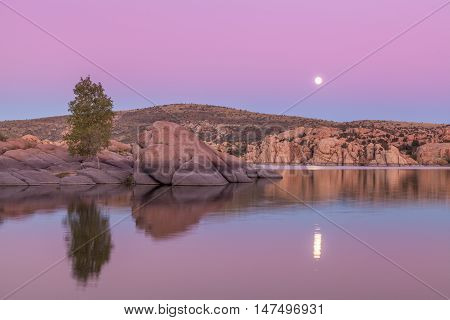 a full moon rising over watson lake presort arizona just after sunset