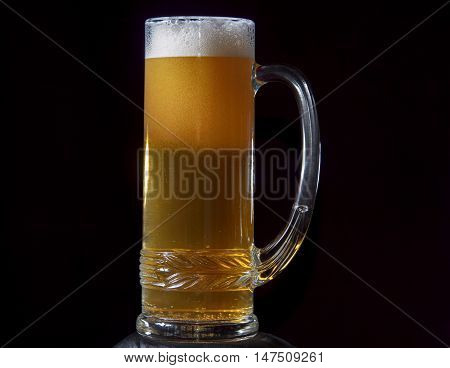 Single heavy glass of beer on black background.