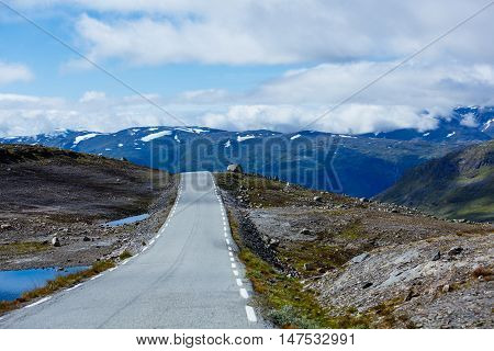Asphalt road in Norway with snowy mountains in the background
