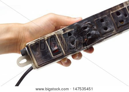 Hands holding a surge protector caught on fire due to overheat