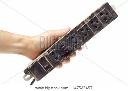Hands holding a surge protector caught on fire due to overheating