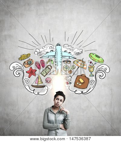 Portrait of African American girl standing near concrete wall with travel sketches on it. Concept of vacation planning