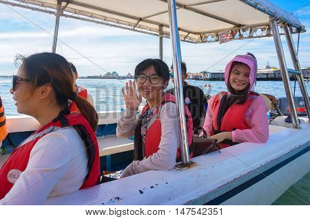 Semporna,Sabah-Sept 10,2016:Tourists Asian smiling for a photograph at the Semporna jetty. Semporna is a gateway for diving & snorkeling trips to the islands of Sipadan,Mabul,Mataking,Maiga & others