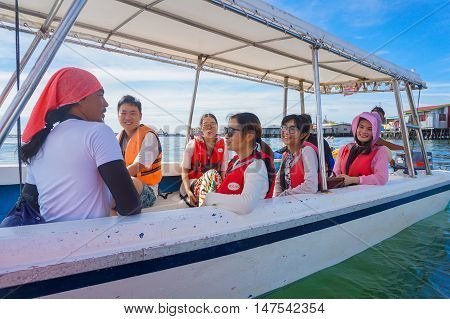 Semporna,Sabah-Sept 10,2016:Happy Asian tourists on the boat at the Semporna jetty.Semporna is a gateway for diving & snorkeling trips to the islands of Sipadan,Mabul,Mataking,Maiga & others