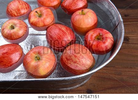 A metal tub filled with water and apples for the Halloween custom of Apple Bobbing.