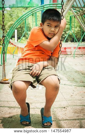 asian child little boy sad alone at playground