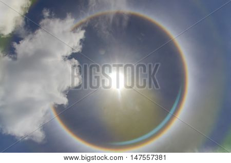 Sun with circular rainbow sun halo occurring due to ice crystals in atmosphere in thai