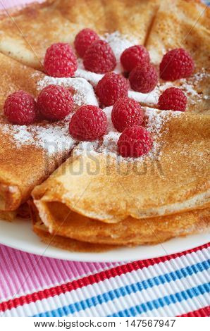 Raspberry pancakes served with sugar powder and berries