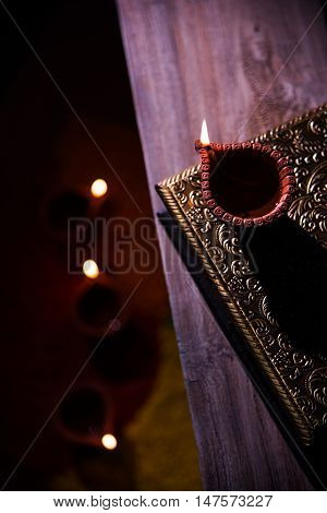 beautiful diwali diya with fire crackers and sweet pera, selective focus