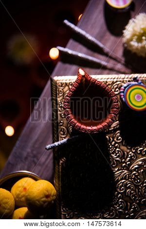 beautiful diwali diya with fire crackers and sweet pera, selective focus