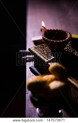 beautiful diwali diya with fire crackers and sweet pera, selective focus