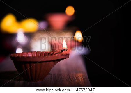 beautiful diwali diya with fire crackers and sweet pera, selective focus