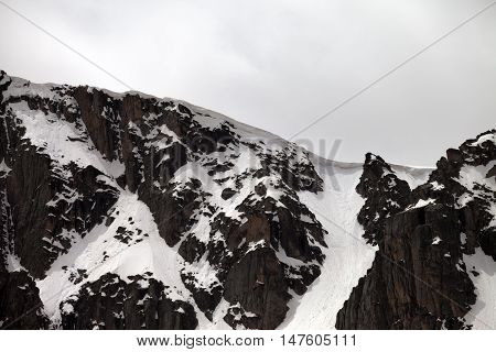 Rocks With Snow Cornice In Gray Day