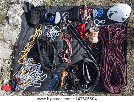 Climbing gear laid out on a stone in front of the ascent.